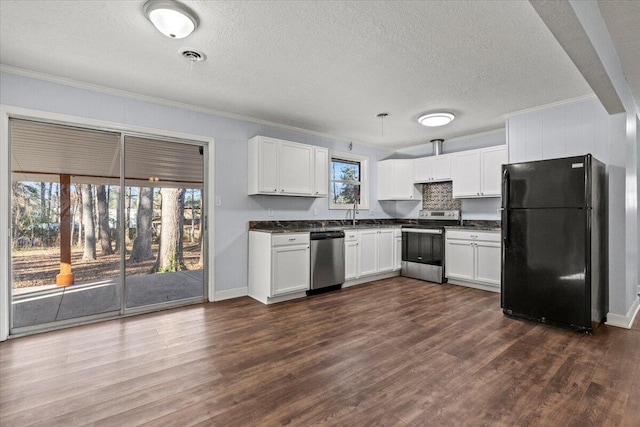 kitchen with appliances with stainless steel finishes, dark hardwood / wood-style flooring, white cabinets, and a wealth of natural light