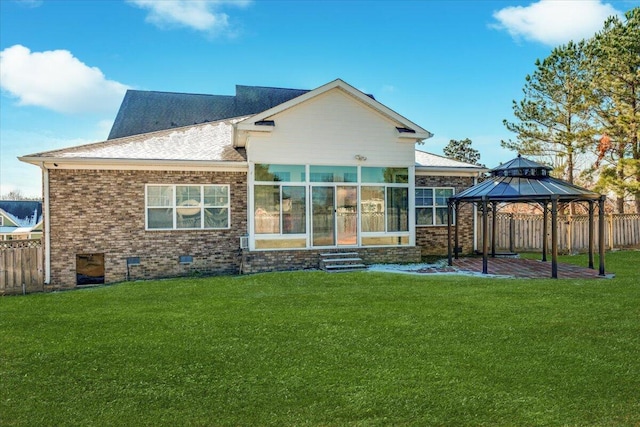 rear view of house with a gazebo and a lawn