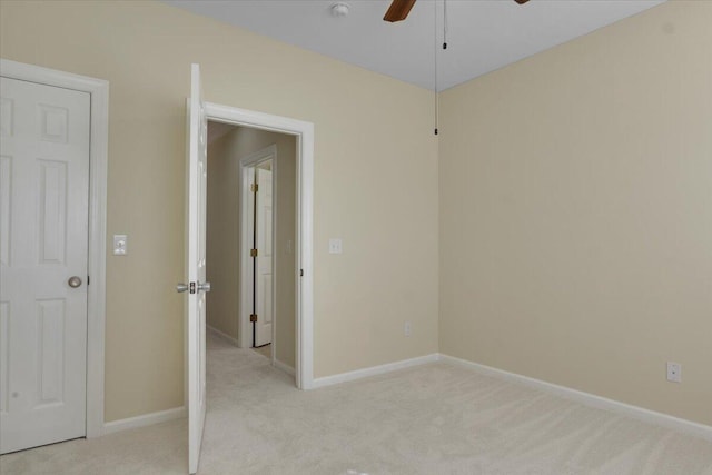 spare room with ceiling fan and light carpet