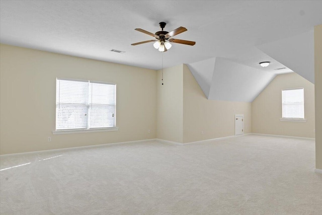 additional living space featuring ceiling fan, light colored carpet, and vaulted ceiling