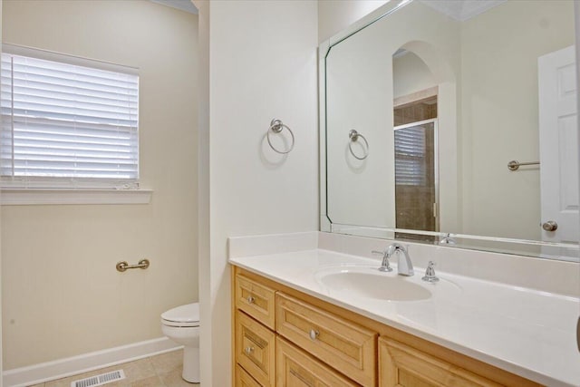 bathroom featuring vanity, a shower with shower door, tile patterned floors, and toilet