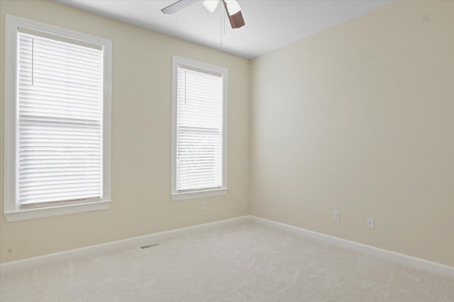 empty room featuring ceiling fan and light colored carpet