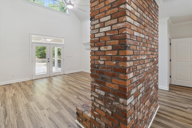 interior space featuring baseboards, wood finished floors, a wealth of natural light, and ornamental molding