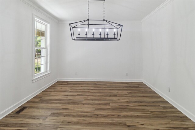 unfurnished dining area featuring baseboards, a notable chandelier, dark wood finished floors, and crown molding