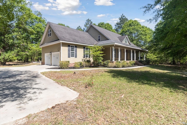 view of front of home featuring driveway, roof with shingles, covered porch, an attached garage, and a front lawn
