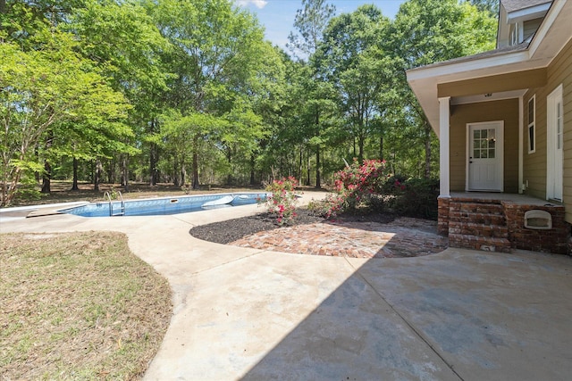 pool with a diving board and a patio