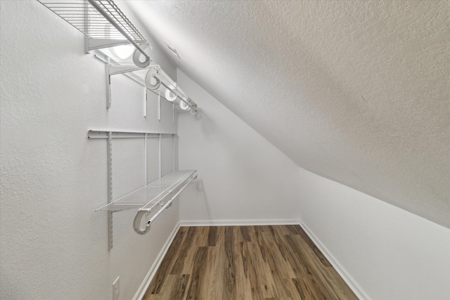spacious closet featuring lofted ceiling and wood finished floors
