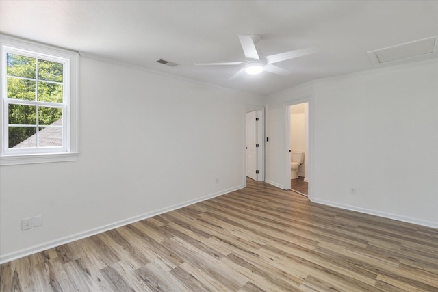 empty room featuring visible vents, light wood-style flooring, and baseboards