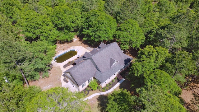 birds eye view of property featuring a view of trees
