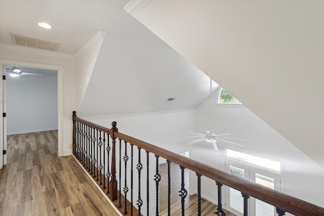 hallway with visible vents, wood finished floors, an upstairs landing, and crown molding
