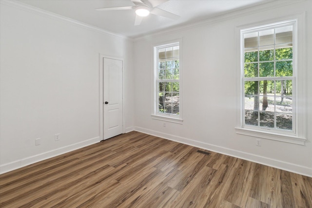 unfurnished room with wood finished floors, ceiling fan, plenty of natural light, and ornamental molding