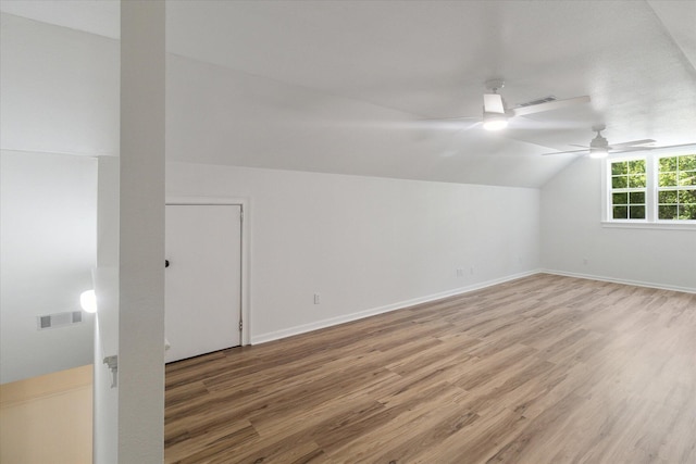 additional living space with light wood finished floors, visible vents, and lofted ceiling