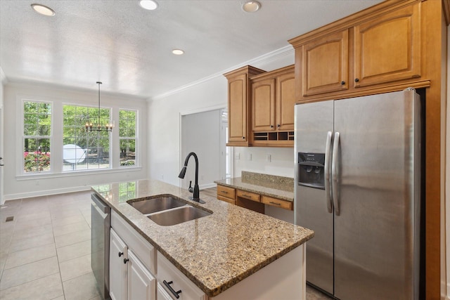 kitchen featuring an island with sink, light stone counters, appliances with stainless steel finishes, a sink, and crown molding