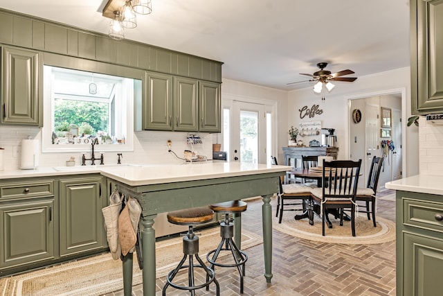 217 Longmeadow Rd, North Augusta, SC 29860 - kitchen featuring green cabinetry, brick flooring, tasteful backsplash, light countertops, and crown molding