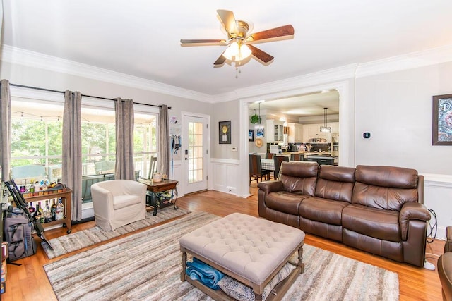 701 Fosters Ct, Evans, GA 30809 - living area with a ceiling fan, crown molding, wood finished floors, a decorative wall, and wainscoting