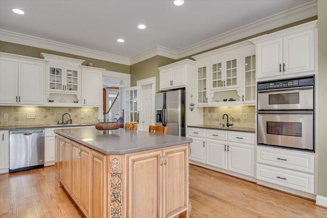 kitchen featuring a sink, appliances with stainless steel finishes, tasteful backsplash, and light wood-type flooring