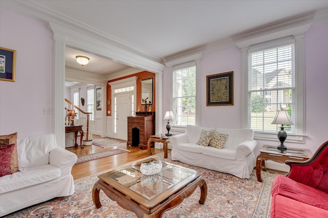 living area with crown molding, stairs, and wood finished floors