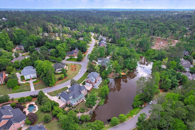 drone / aerial view with a water view, a residential view, and a wooded view