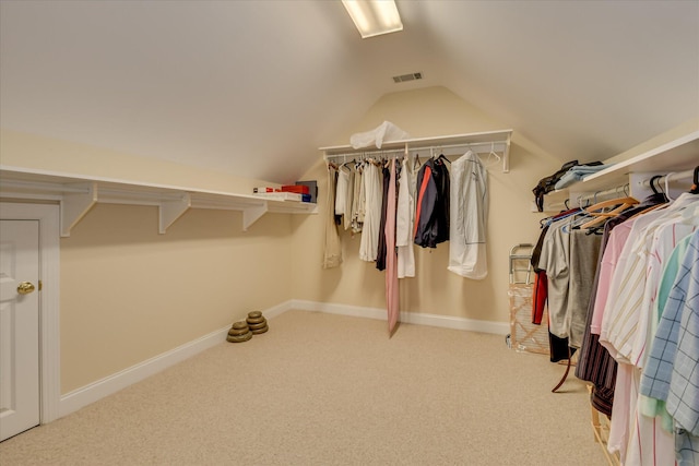 spacious closet with visible vents, carpet, and vaulted ceiling