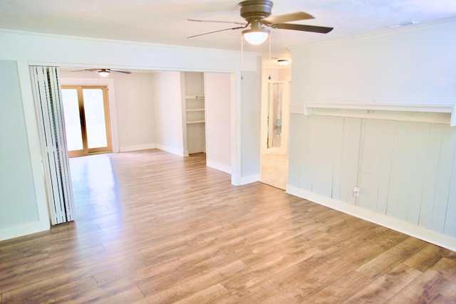 empty room with ceiling fan, ornamental molding, and wood finished floors