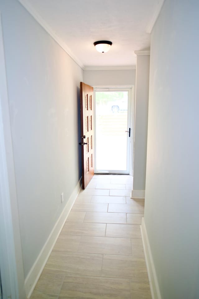hall with crown molding, baseboards, and light wood-type flooring