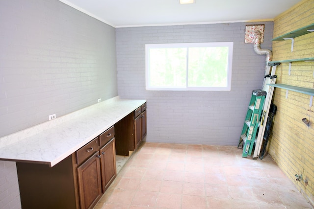interior space featuring crown molding and brick wall