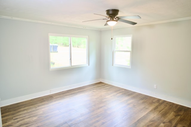 empty room with crown molding, baseboards, ceiling fan, and wood finished floors