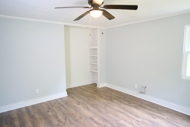 unfurnished room with crown molding, a ceiling fan, baseboards, and wood finished floors