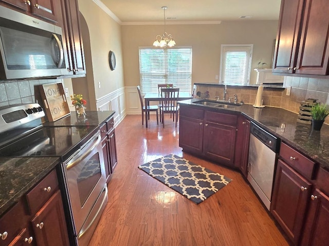 2144 Willhaven Dr, Augusta, GA 30909 - kitchen featuring stainless steel appliances, a chandelier, a peninsula, wood finished floors, and ornamental molding