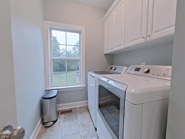 laundry room featuring plenty of natural light, cabinets, and separate washer and dryer