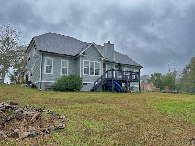 rear view of property featuring a yard and a wooden deck