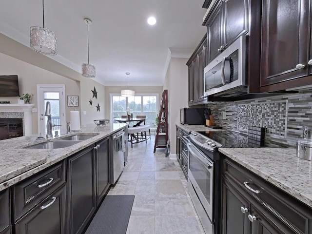 kitchen featuring appliances with stainless steel finishes, backsplash, dark brown cabinetry, sink, and pendant lighting