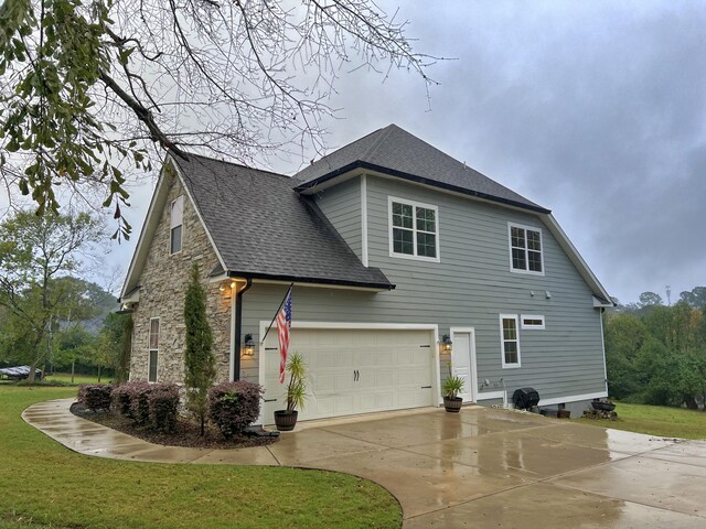 view of side of home with a yard and a garage