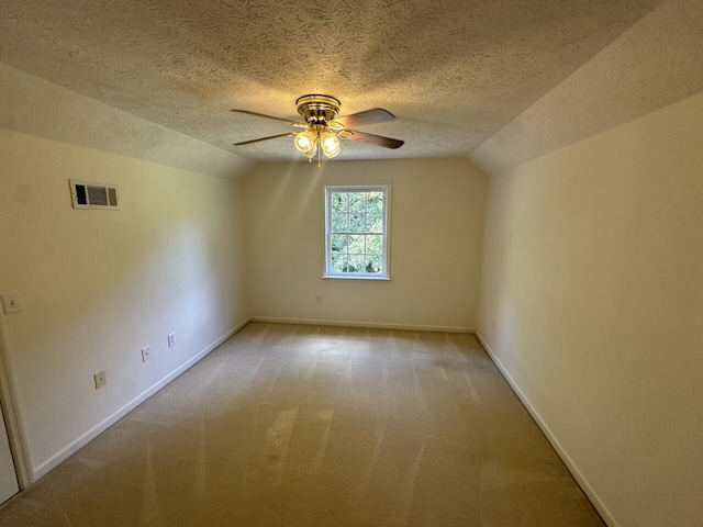 additional living space featuring a textured ceiling, ceiling fan, light carpet, and lofted ceiling