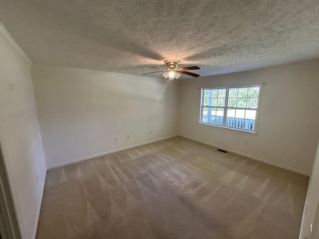 spare room with light carpet, a textured ceiling, ceiling fan, and ornamental molding