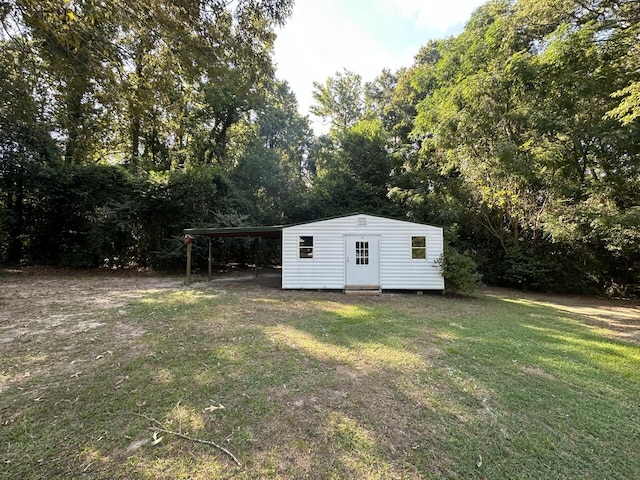 view of outbuilding with a yard and a carport