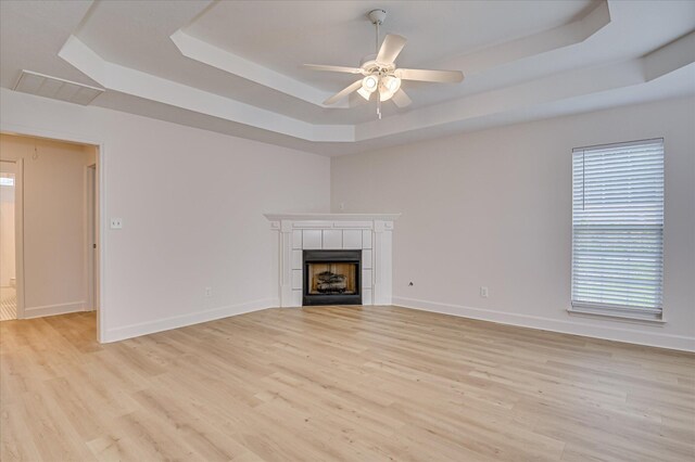 4002 Hidden Haven Ct, Augusta, GA 30909 - unfurnished living room featuring a raised ceiling, a ceiling fan, light wood finished floors, a tile fireplace, and baseboards
