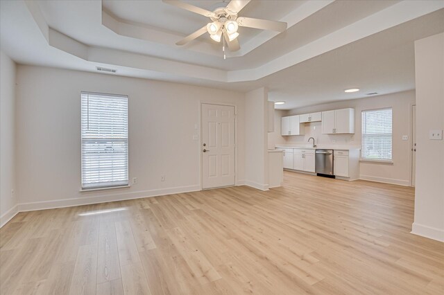 4002 Hidden Haven Ct, Augusta, GA 30909 - unfurnished living room featuring a sink, baseboards, light wood-style floors, a tray ceiling, and ceiling fan