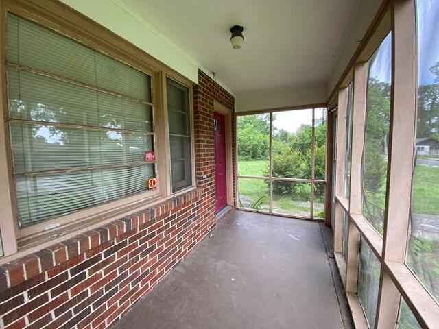 1012 14th Ave, Augusta, GA 30901 - unfurnished sunroom featuring brick wall and concrete floors