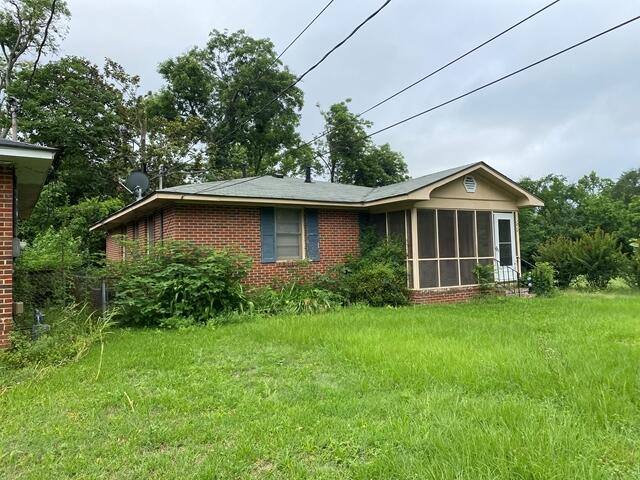 1012 14th Ave, Augusta, GA 30901 - back of property with brick siding, a sunroom, and a lawn