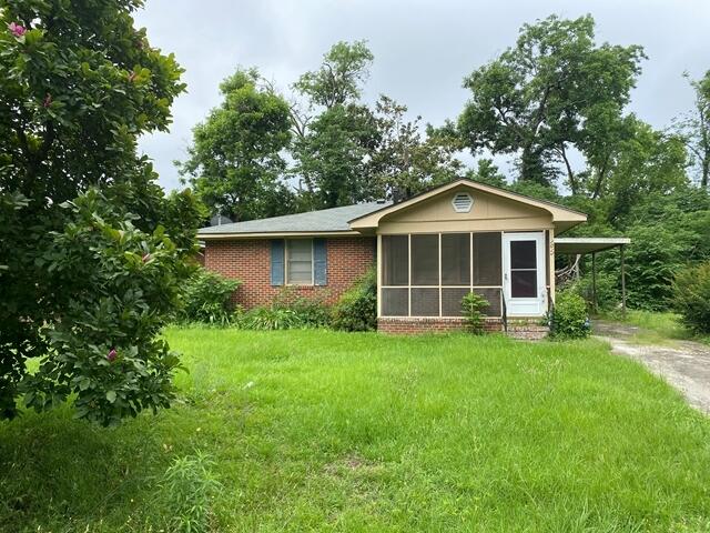 1012 14th Ave, Augusta, GA 30901 - view of front of home featuring a sunroom, driveway, a front lawn, and brick siding