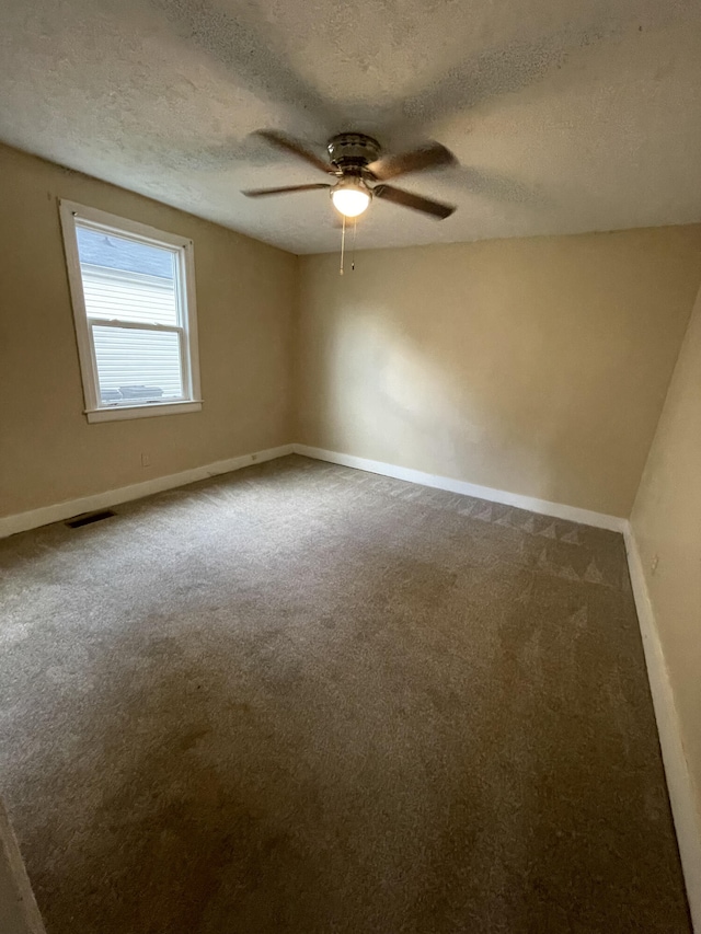 carpeted empty room featuring a textured ceiling and ceiling fan