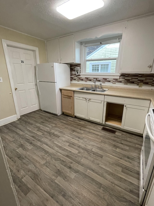 kitchen with white cabinetry, sink, stove, and white refrigerator