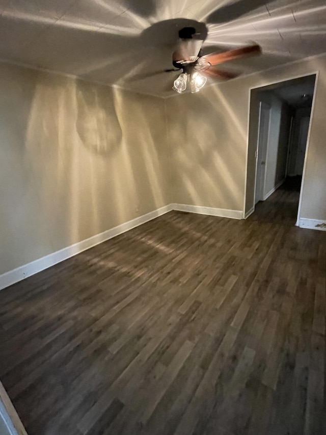 spare room with dark hardwood / wood-style flooring and ceiling fan