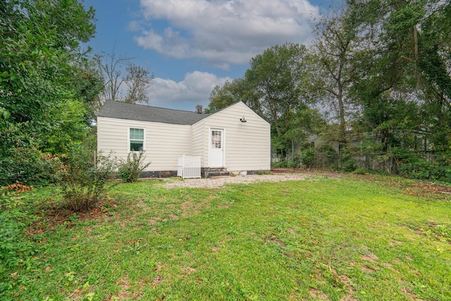 rear view of house featuring a lawn