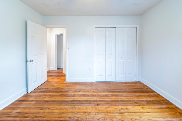 unfurnished bedroom with light wood-type flooring and a closet