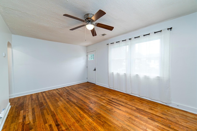 empty room featuring ceiling fan, wood-type flooring, and a textured ceiling