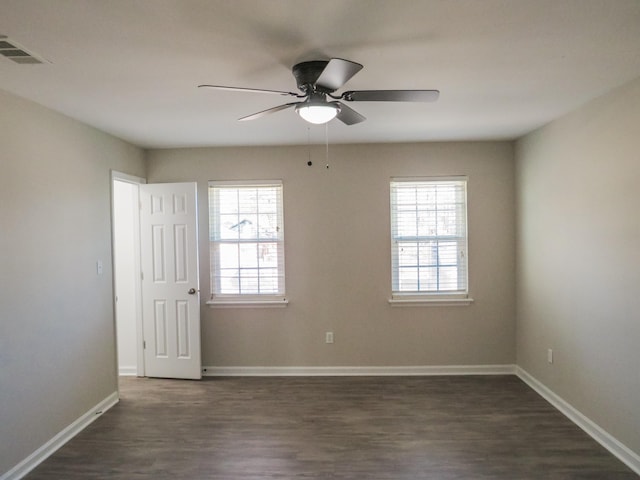 spare room featuring dark wood-type flooring and ceiling fan