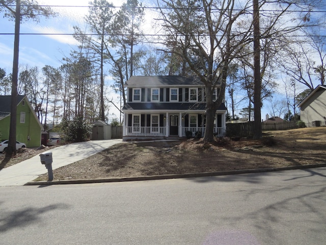 colonial house with a storage unit and a porch