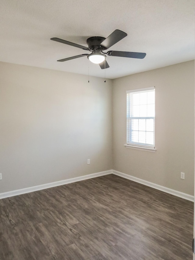 empty room with dark wood-type flooring and ceiling fan